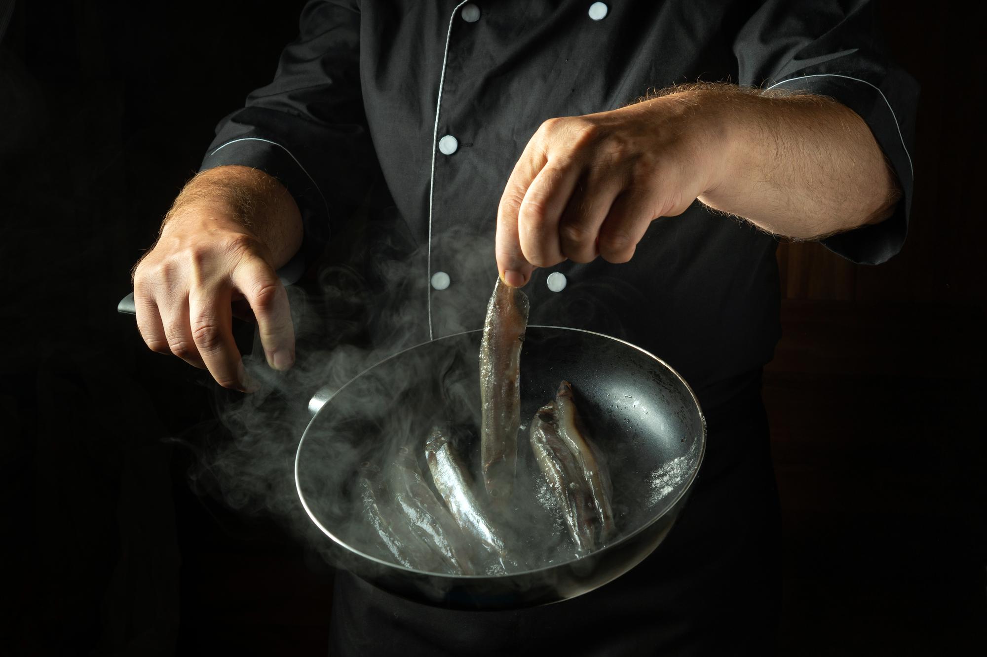 chef arranging plated futuristic dish on stainless table